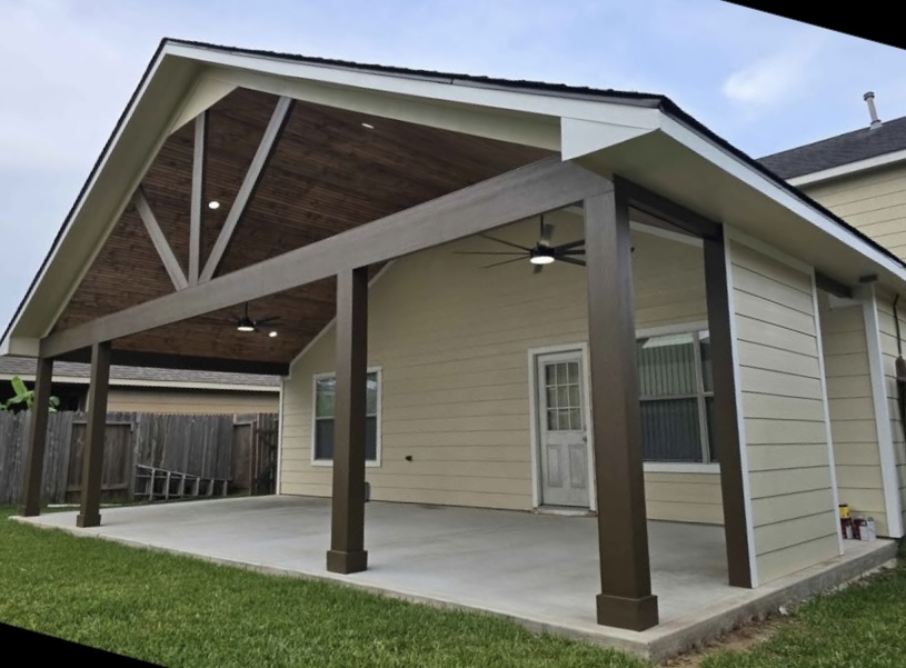 Completed gabled covered patio with stained wood posts, wood ceiling, lighting, and ceiling fan